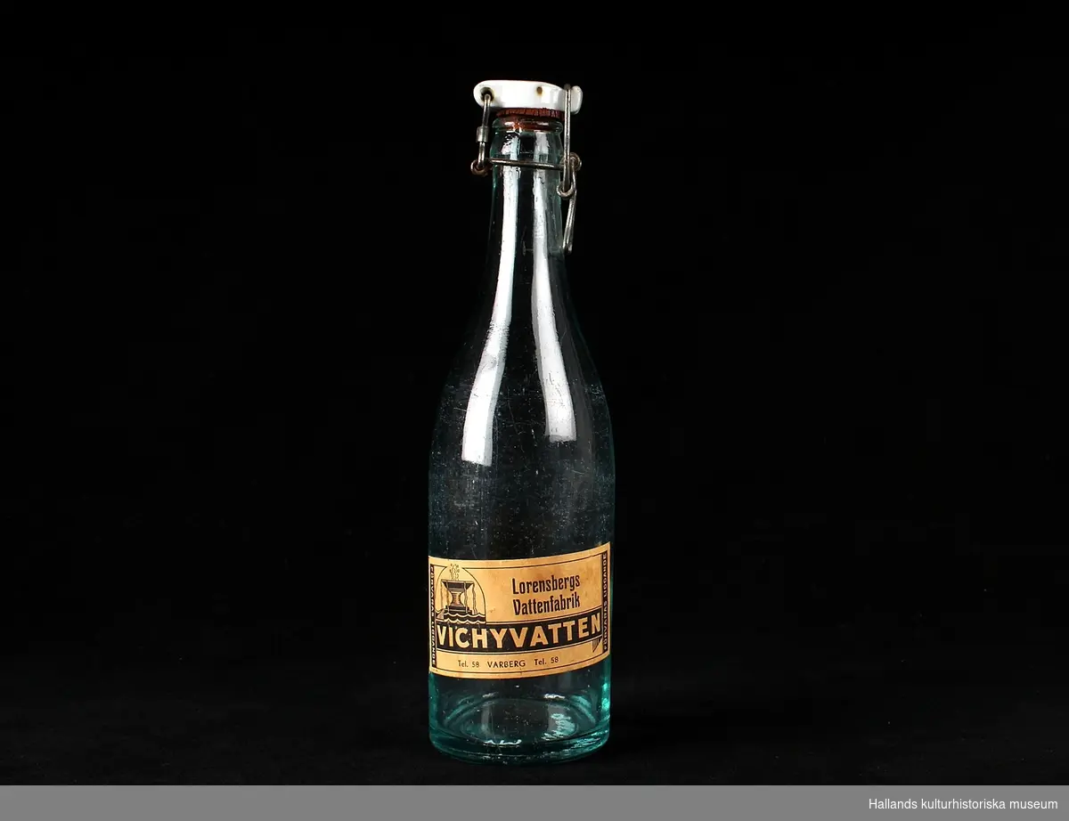 Vichyvattenflaska av glas med etikett av papper och kapsyl av porslin.