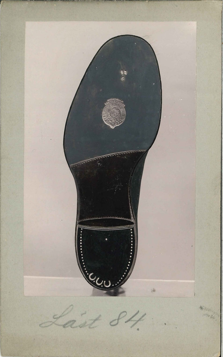 Fotografi av ett skodon. Sko. Bild på undersidan av skon.

Använd som reklam på A F Carlssons skofabrik.

Ingår i en samling med 123 stycken kort i kartong.