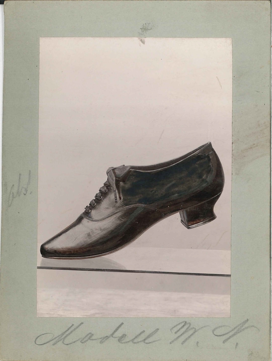 Fotografi av ett skodon. Damsko med snörning. 

Använd som reklam på A F Carlssons skofabrik.

Ingår i en samling med 123 stycken kort i kartong.