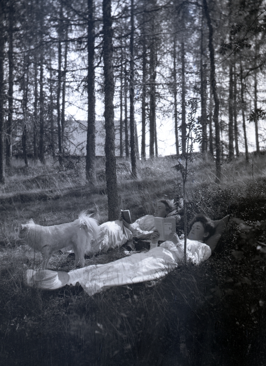 Nina Hammarskjöld överst och en dam med en hund i skogen i närheten av Tuna gård.