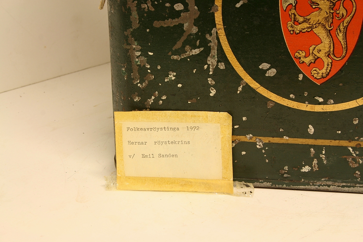 Avrundet, rektangulær boks. Den norske løve på fronten. Rødt segl på begge kortsidene. Hvit hyssing.