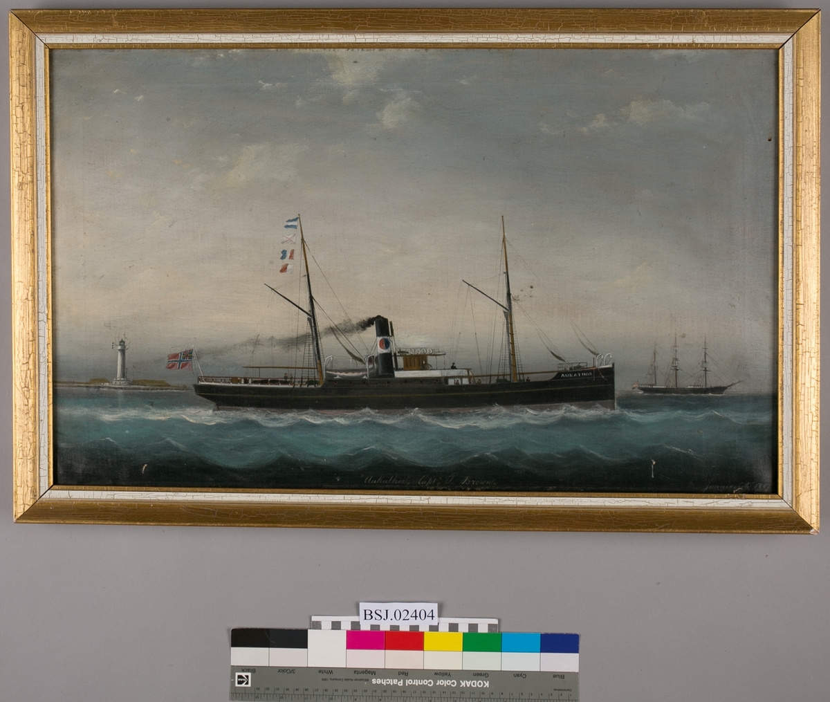 Skipsportrett av DS AUKATHOR under fart. Ser et fyrtårn akter og seilskip foran baugen på AUKATHOR. Unionsflagg akter.