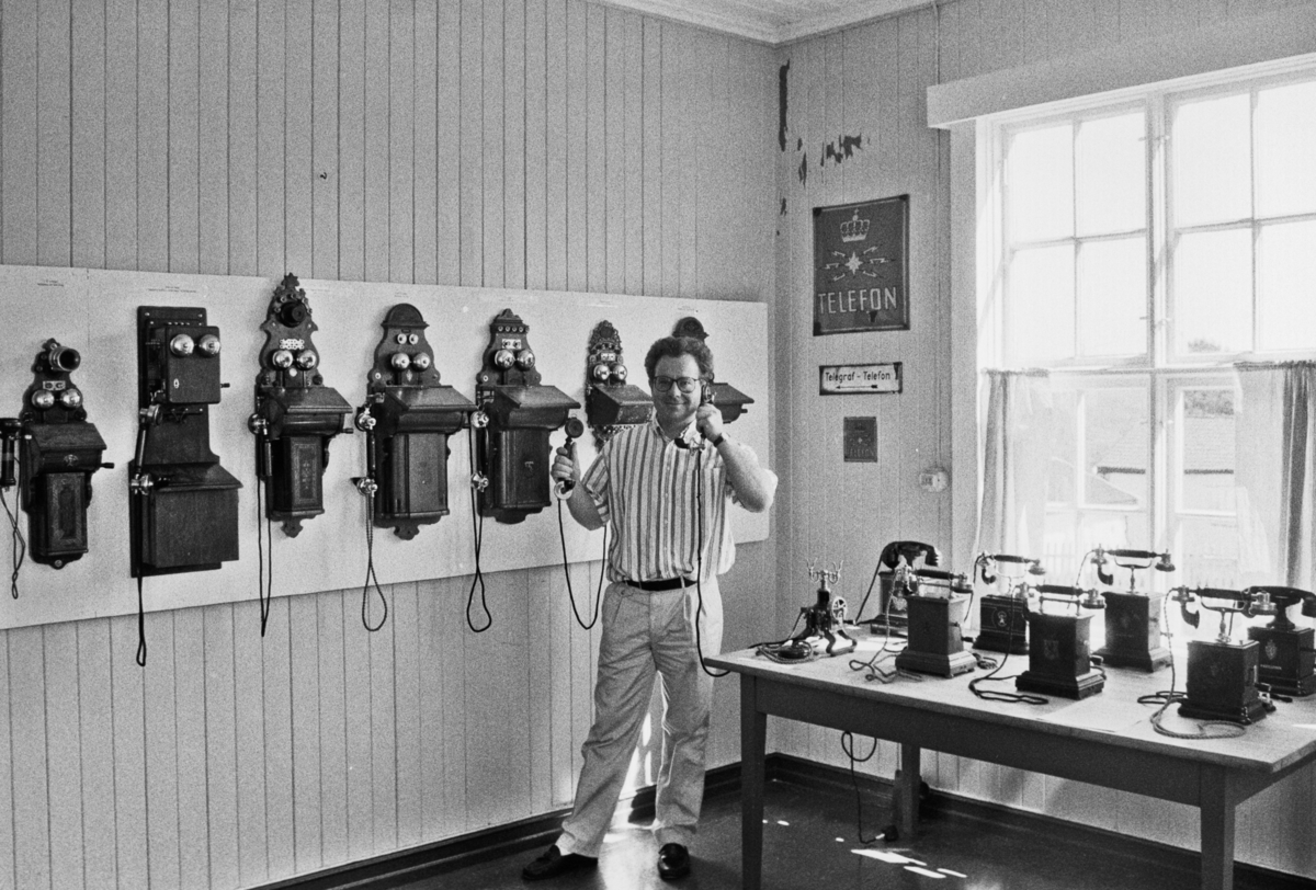 Dagfinn Lunner med gamle telefonapparater. Utstilling av telefoner.