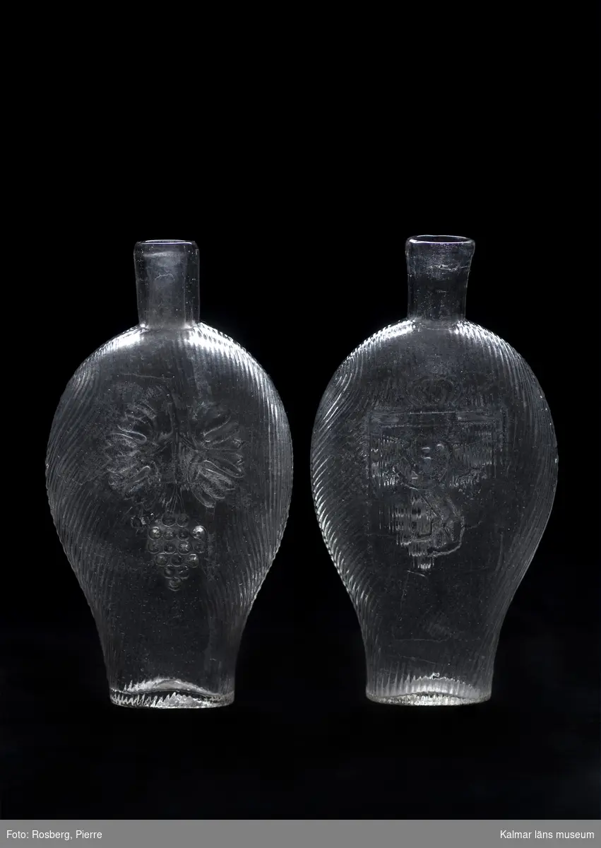 KLM 23287. Brännvinsflaskor av pressglas, 6 stycken. Av typen fickplunta. Höjden varierar något mellan 18,5 cm till 19,2 cm.