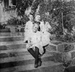 Foto av tre kvinner som sitter på en trapp. Trolig fra famil