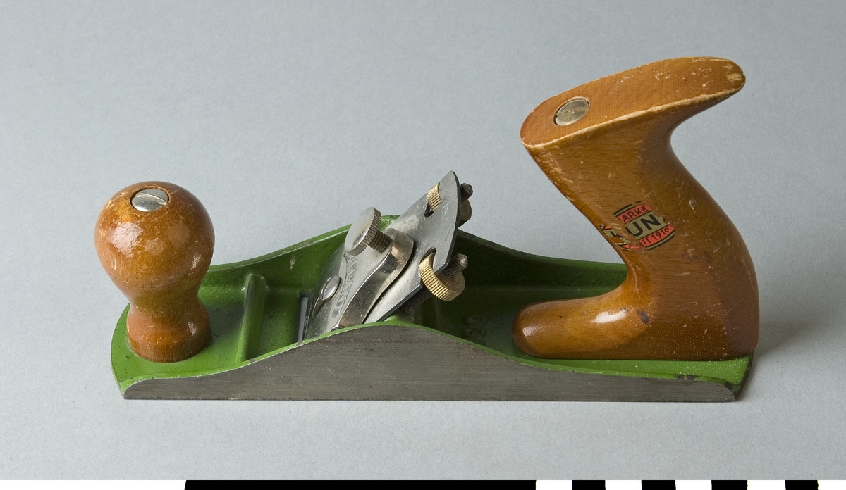 Hyvel av stål. Putshyveln har en svarvad rund träknopp som handtag i den främre delen och ett trähandtag, profilerat, för ett handgrepp i den bakre änden. Handtagen är av trä och brunlackerade. Hyveln är grönmålad på ovansidan. Det bakre handtaget är försett med firmamärke på en trasig klisterlapp där det står MARKE, KUNZ, SEIT 1910. På hyvelstålet är KUNZ instämplat. Klaffen är märkt BRILLIANT. På sulans ovansida står 300 instämplat.
Hyveln är märkt med Stockholms Borgargilles nummer SB 1785.

Funktion: Liten handhyvel för ytor och kanter av mindre arbetsstycken