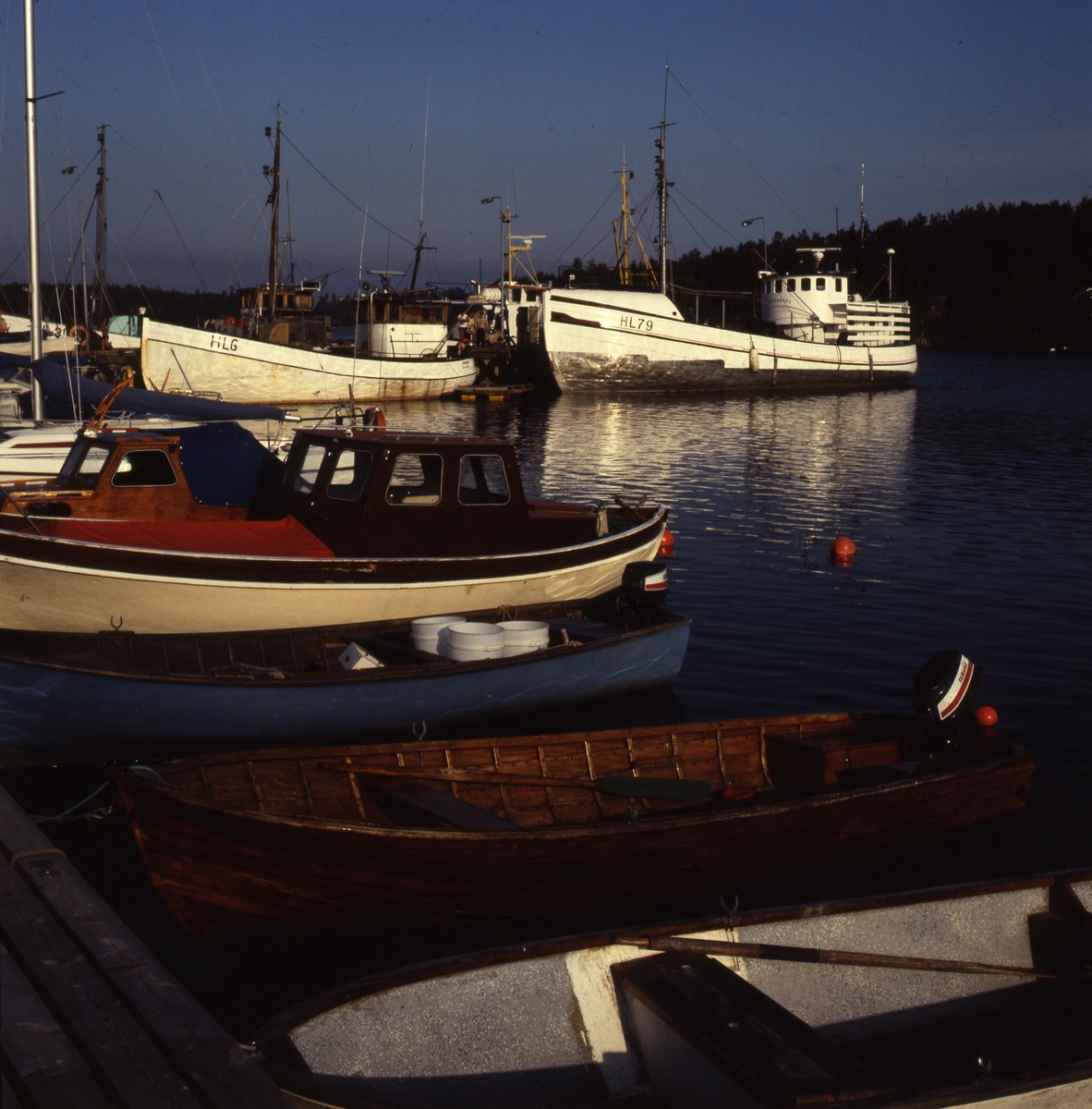 Många olika båtar vid kajen i Mellanfjärdens fiskeläge i Jättendal.