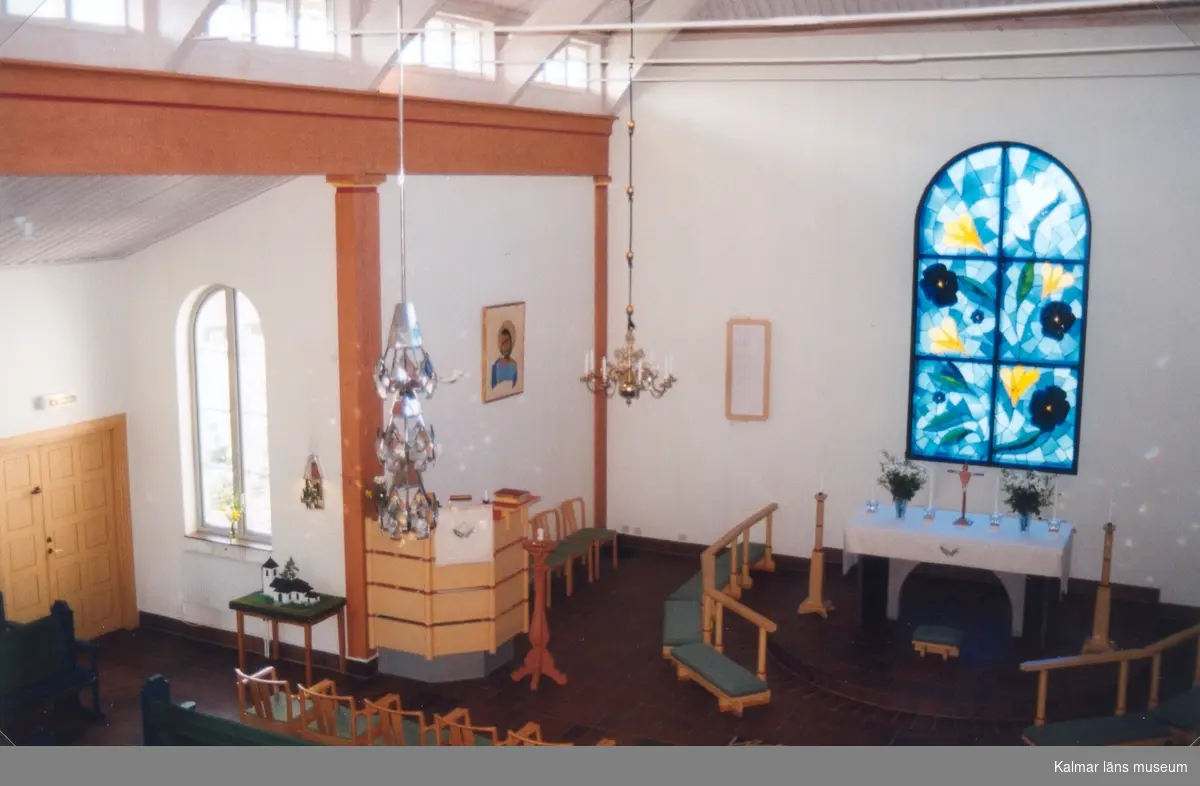 Altaret i Hälleberga kyrka med korfönstret "Himmelrikets blomster" av konstnären Britta Reich-Eriksson.