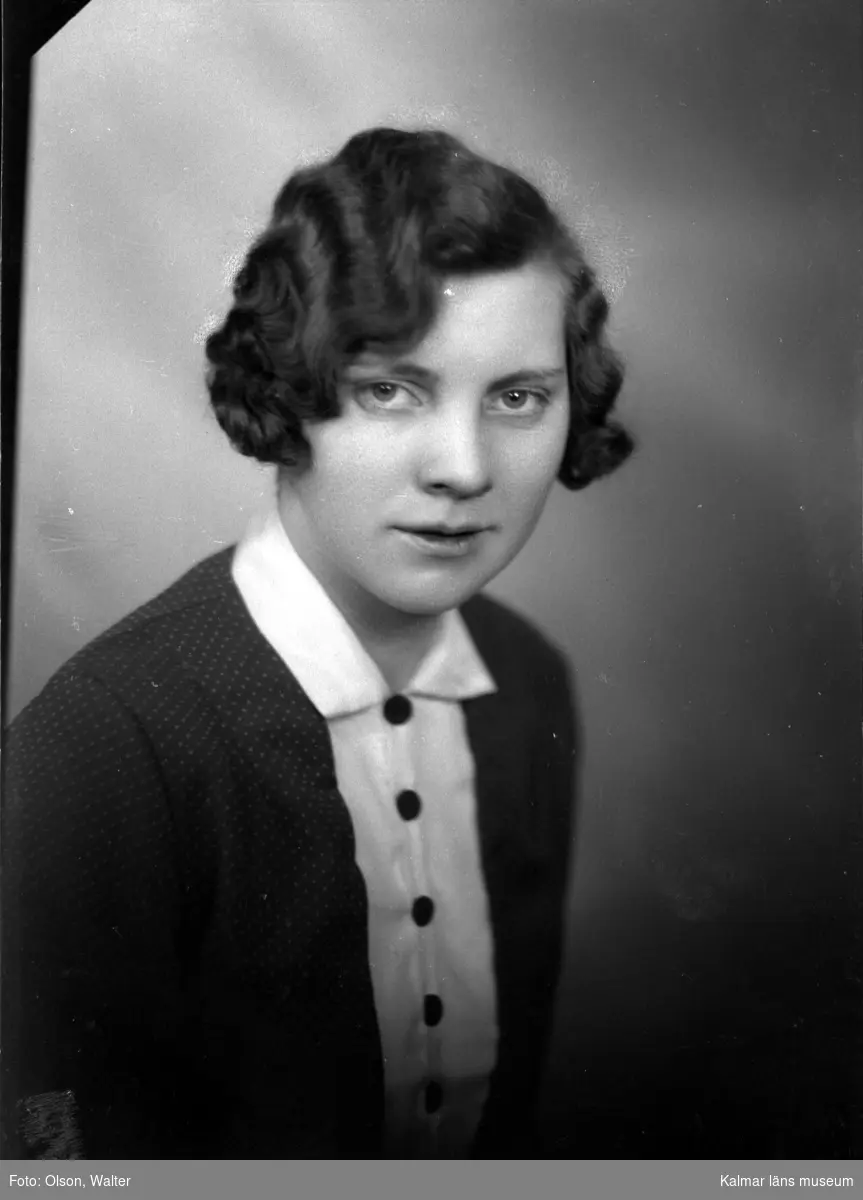 Ateljébild på en kvinna i halsband och klänning. Enligt Walter Olsons journal är bilden beställd av Julia Andersson ifrån Fjärdsjömåla.