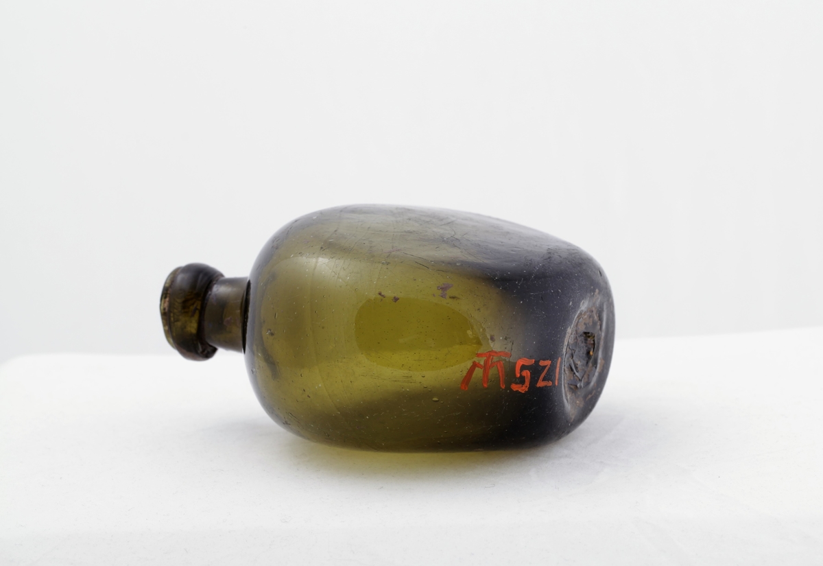 Flaska har form som en flattrykt kule og har kort hals som avsluttes med en ring øverst.