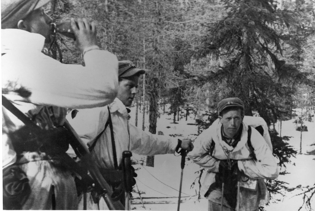 Vinterövning, soldater rastar i snöklädd skog.
