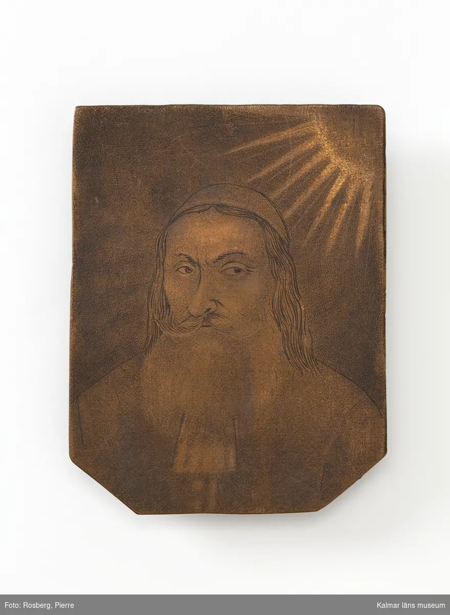 Porträtt av en präst med skägg och långt hår, försedd med huvudbonad. I övre vänstra hörnet en sol med korskrönt IHS.