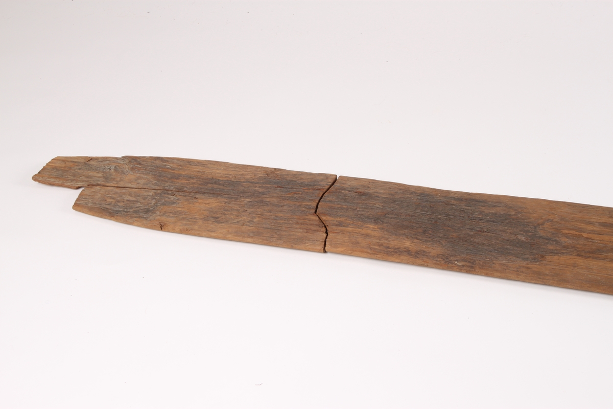 Enkeltski i tre deler med en bred styrerand under. Skien består hovedsakelig av bakski, bindingshull og et lite stykke framski. Bakskien har en avsmalnende form. Bindingshullet er ødelagt. Oversiden av skien har spor etter linjer og er et tidlig eksempel på strekmåtdekor.