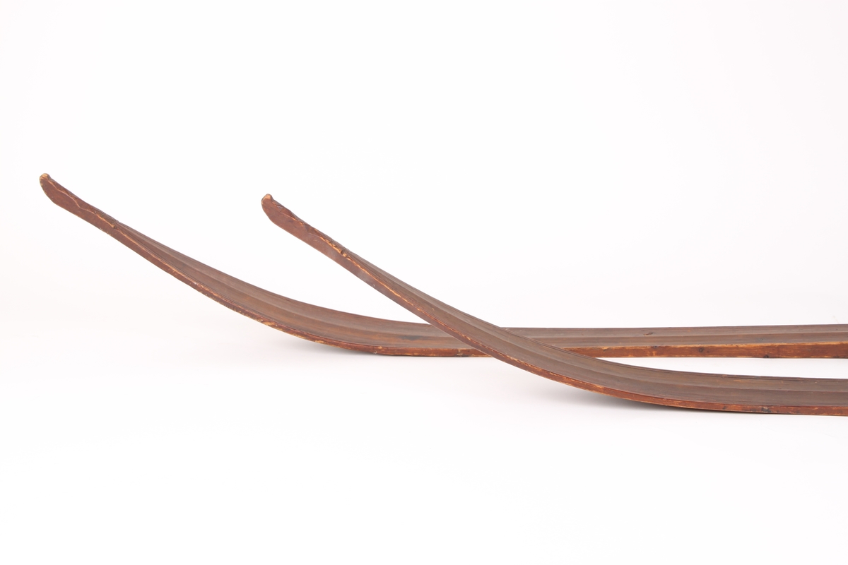 Et par treski i helved med avsmalnende framski og jevnbred bakski. Skiene har strekmåtdekor og svakt møne langs hele oversiden. Lang skitupp med geometriske innskjæringer på oversiden. Skienes bakende er plane og rett avskåret. Det er to bindingshull gjennom skien og fotstegplate på oversiden. Enkel rand under skien.