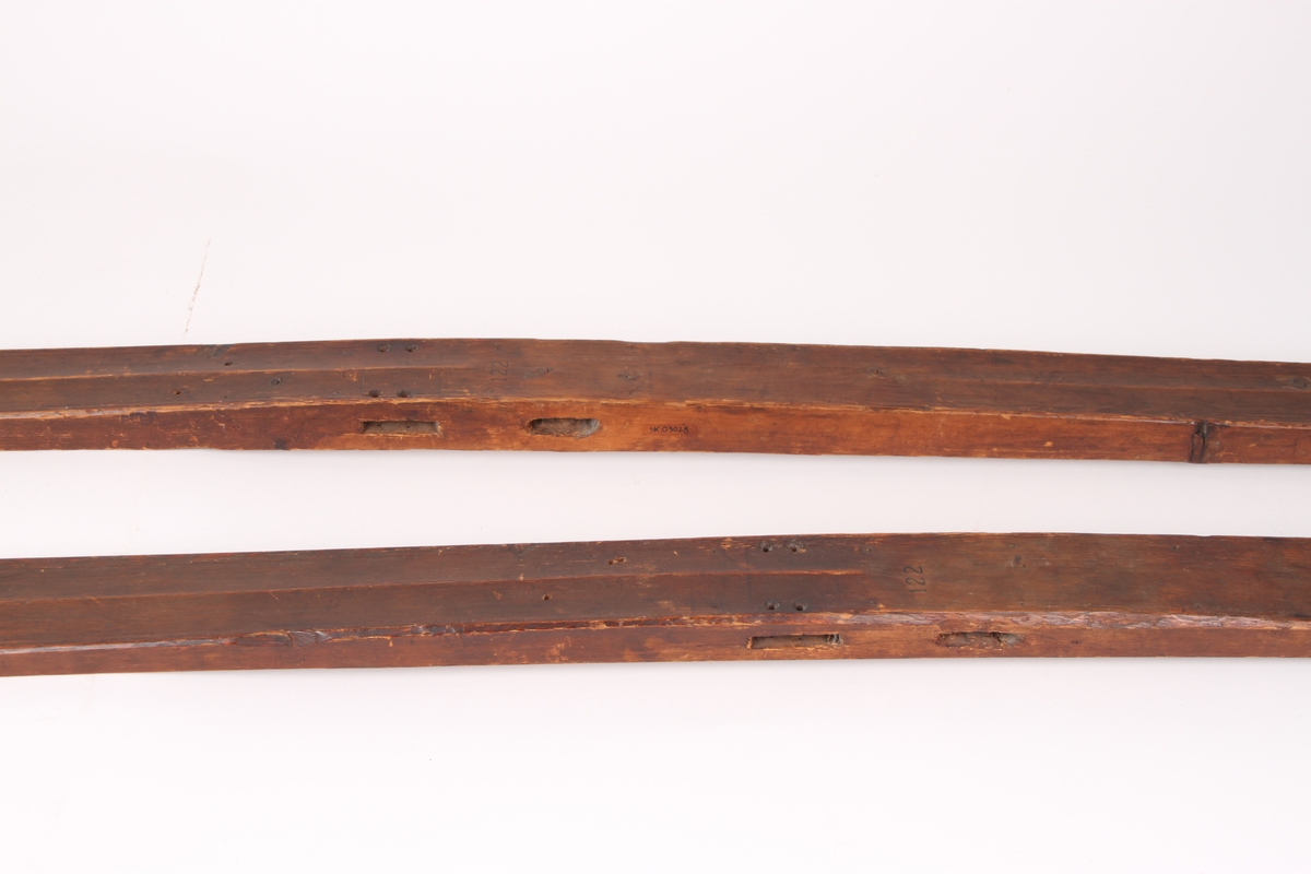 Et par treski i helved med avsmalnende framski og jevnbred bakski. Skiene har strekmåtdekor og svakt møne langs hele oversiden. Lang skitupp med geometriske innskjæringer på oversiden. Skienes bakende er plane og rett avskåret. Det er to bindingshull gjennom skien og fotstegplate på oversiden. Enkel rand under skien.