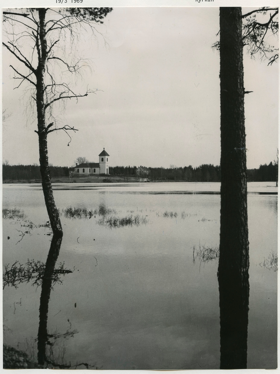 Hälleberga kyrka omgivet av ett översvämmat landskap.