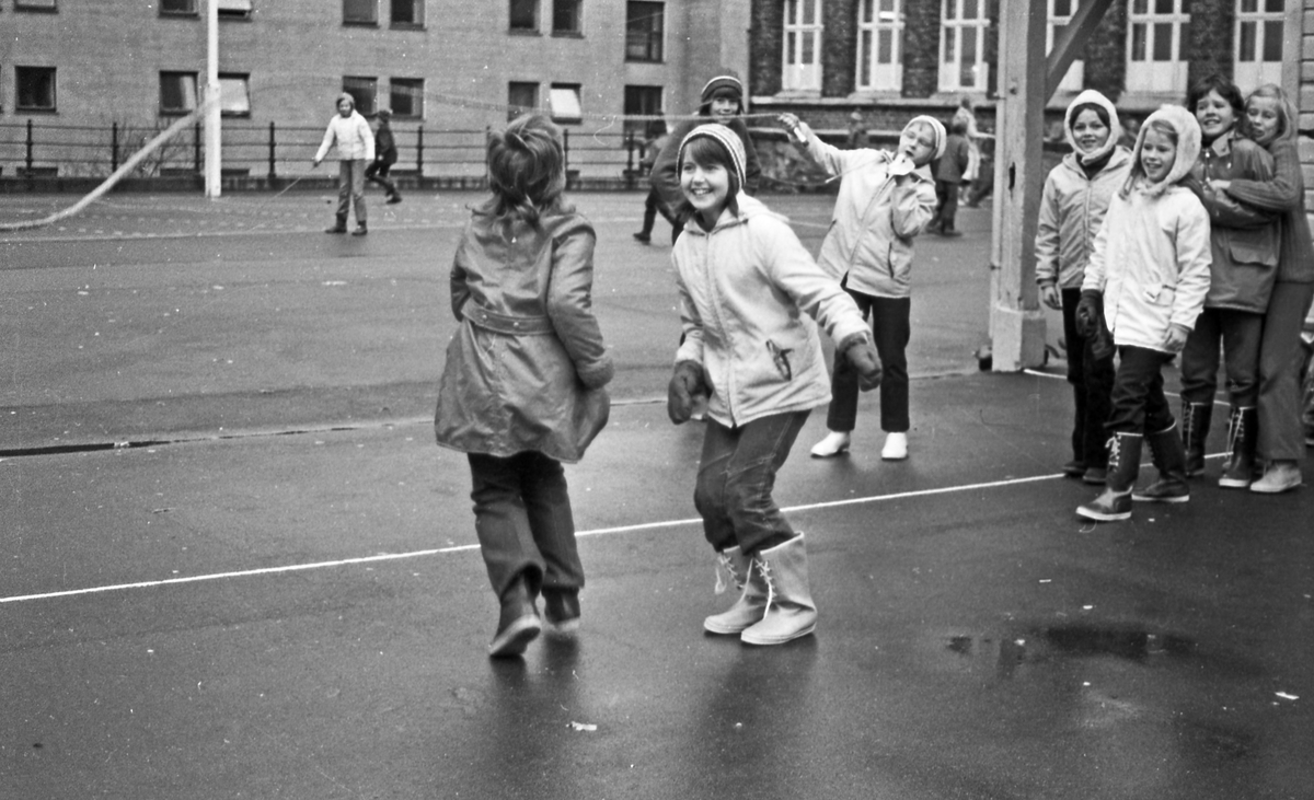 Skolebarn. På Breidablikk skole bruker man friminuttet til lek selv om været ikke er det beste.