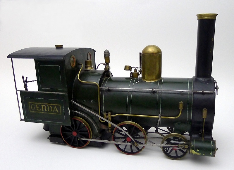 Modell av tenderlok, med tender, årsmodell 1878. Namnet Gerda är målat på loket. I tendern finns vissa tillbehör.