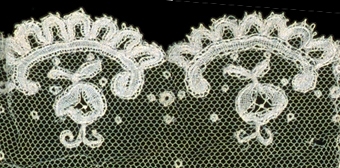 Manschett av vit tyll med mönster och uddar med söm på mitten.


Neg.nr: 1989-02