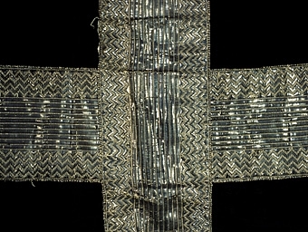 Mässhake av silkesammet med silverdekorationer. Hebreiskt monogram på framstycket. På bakstycket en korsformad besättning av mönstervävt silverband. Mässhaken har ett brunt linnefoder. Tvättad på Riksantikvarieämbetet och även förvarad där under flera år.


Neg.nr: 1983