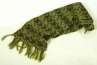 Halsduk stickad av ullgarn i brunt, grått och gulrött. Knuten frans i samma färger.



Neg.nr: 1987-04