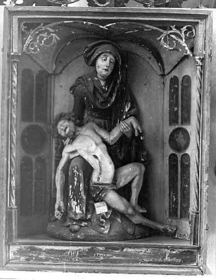 I Västergötlands museums samlingar. 
Inv.nr. 7798

PietÃ , framställning av den sörjande jungfru Maria, sittande med den döde Kristus i sitt knä. Motivet har sin bakgrund i senmedeltidens passionsmystik och uppstod i Rhenområdet i början av1300-talet. Det blev därefter vanligt i både måleri och skulptur. En ensam sörjande Maria kallas mater dolorosa. 
http://www.ne.se/jsp/search/article.jsp?i_art_id=283310