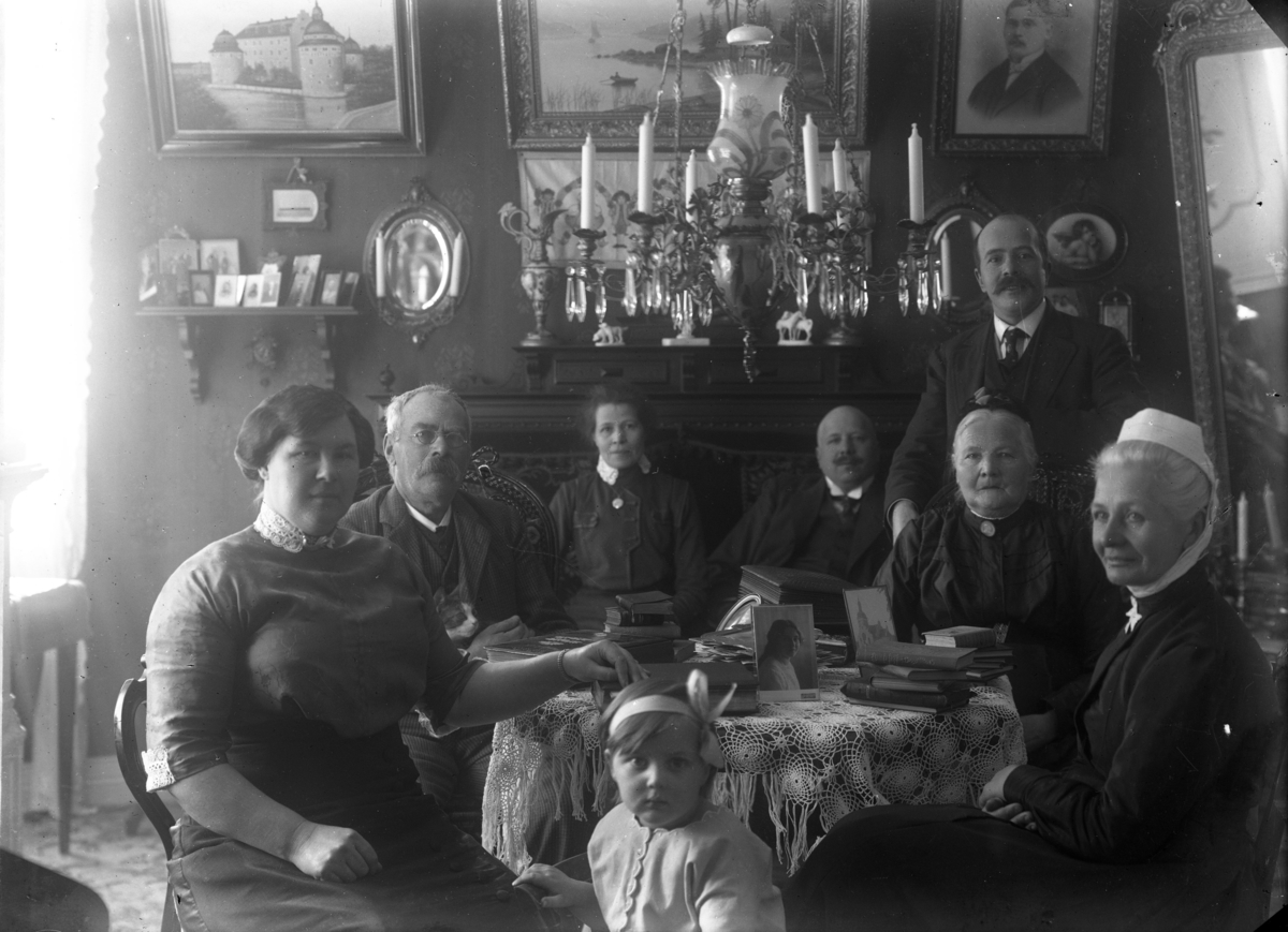 Interiör hos familjen Rythén i Gränna. Tvåa och trea fr vänster är Alexis och dottern Anna. Sittande två från höger är Anna Maja, hustru och mor. I övrigt okända personer.