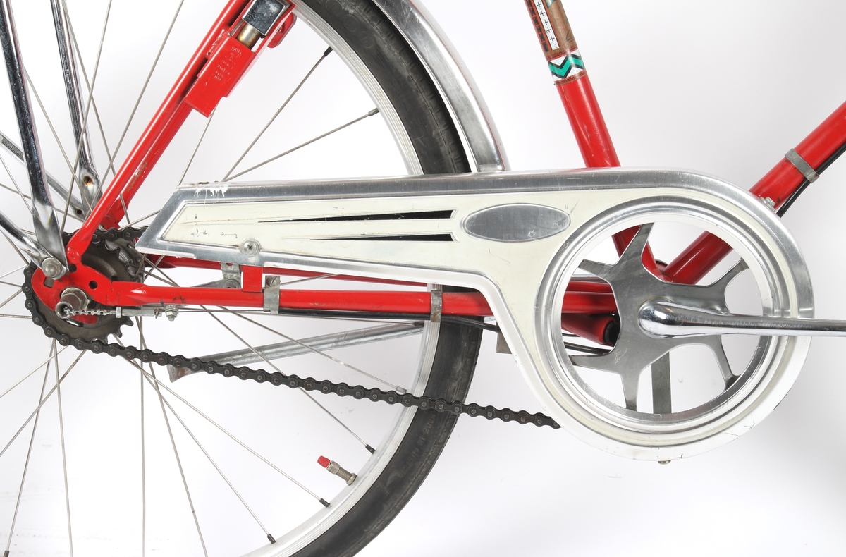 Rød guttesykkel med trippel gir. Sykkelen har to speil og et "dashbord" med reflekser montert på styret.