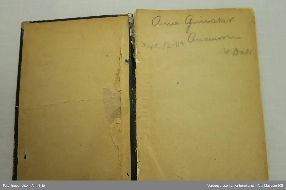 Bok med svarte permer. Ryggen på permen er ødelagt og permene blir holdt sammen av en grå tape.