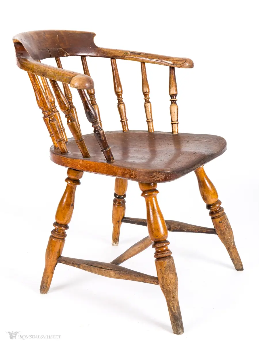 Winsdoor- stol inspirert pinnestol med kraftig skjoldformet sete, tykke dreide ben med H- sprosse imellom. 10 dreide pinner i ryggen som er festet i et avrundety skulderbrett som fortsetter framover og utgjør et par korte armlener