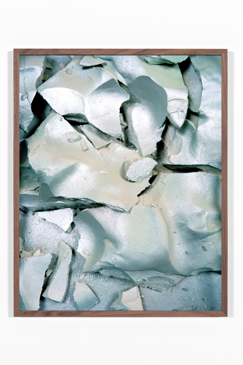 Kunstverket viser et nærbilde av spraymalt leire i metalliske sølv farger.