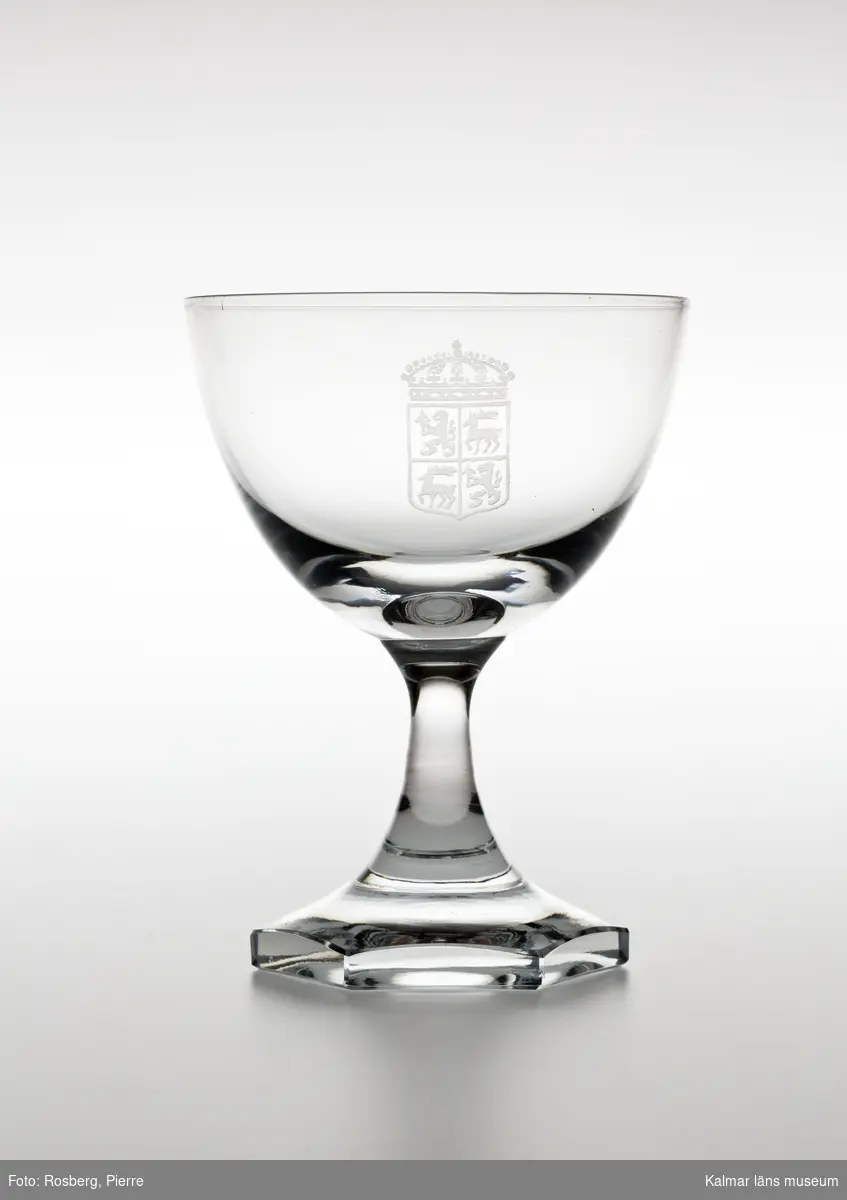 KLM 44717:16 Starkvinsglas, av glas. Glaset är tillverkat av Orrefors glasbruk och kupan är graverad med länsvapnet.