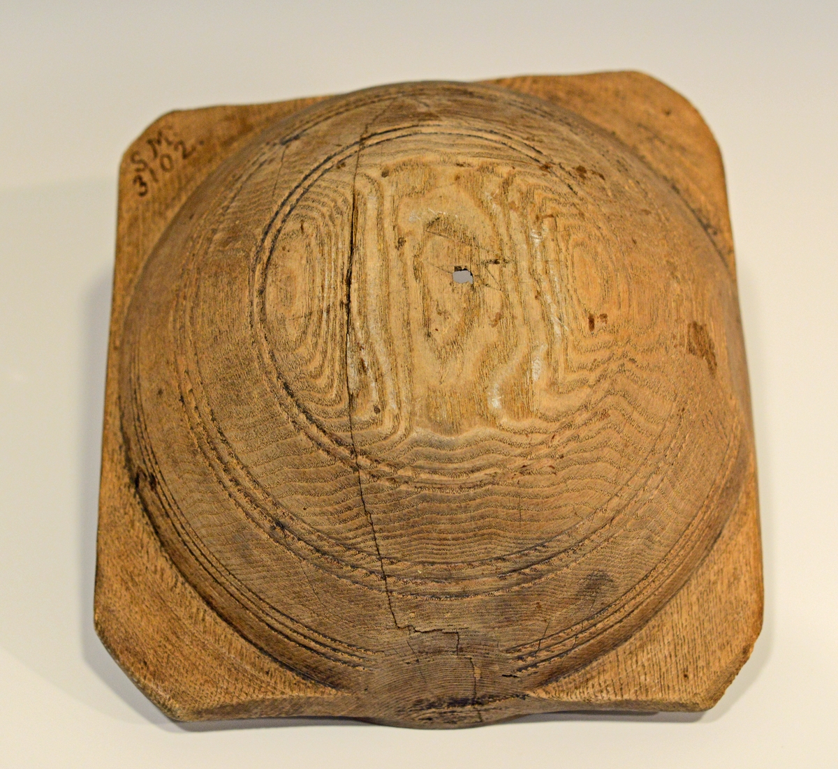 Fra protokollen: 
Rund, halvkugleformig. 4 ører som haandtak.
Smørformen har et lite hull i midten og det ene hjørnet mangler en del.