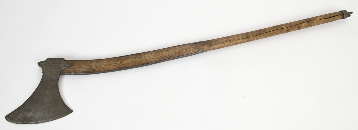 Asymmetrisk blad med lang øvre spiss og kortere nedre spiss.
Bladet er tynt, med påsmidd noe tykkere egg.
Øksehammeren har skaftehull og fliker.
Smedmerke formet som et skjell. Øksen har etset rankedekor på begge sider.
Skaftet er svakt krummet med skinner på rygg-og forside Skinnene har dekor i form av små halvmåner og S. Skaftet er merket ANNO 1758 THS. Skaftet har skåret dekor i felter. Skaftet har doppsko og pigg.