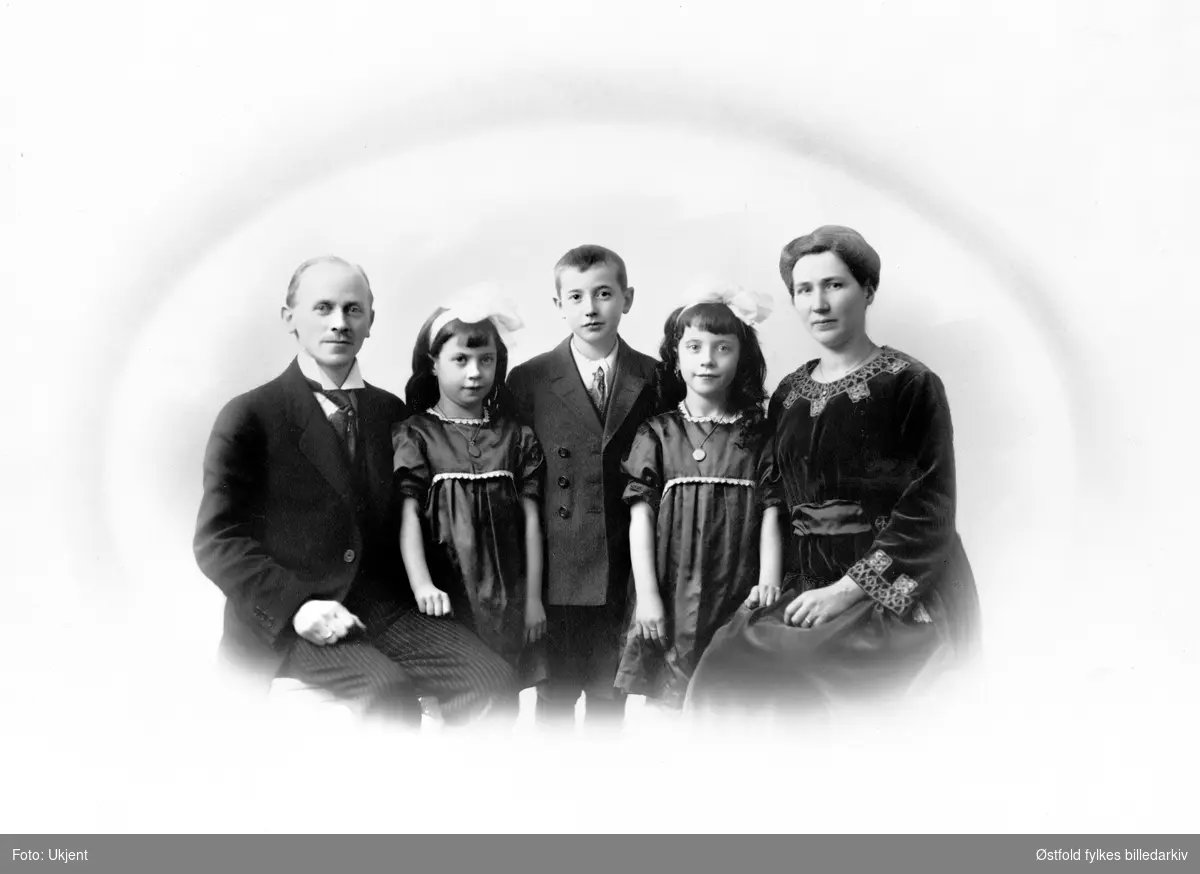 Gruppeportrett av ukjent sittende mann og kvinne med tvillingjenter og gutt, ca. 1915. 1920?