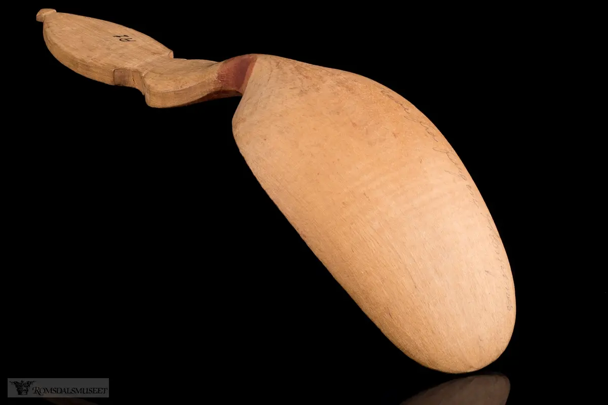 Liljemønster på håndtaket, og rankemønster og røde prikker på selve skjeen.