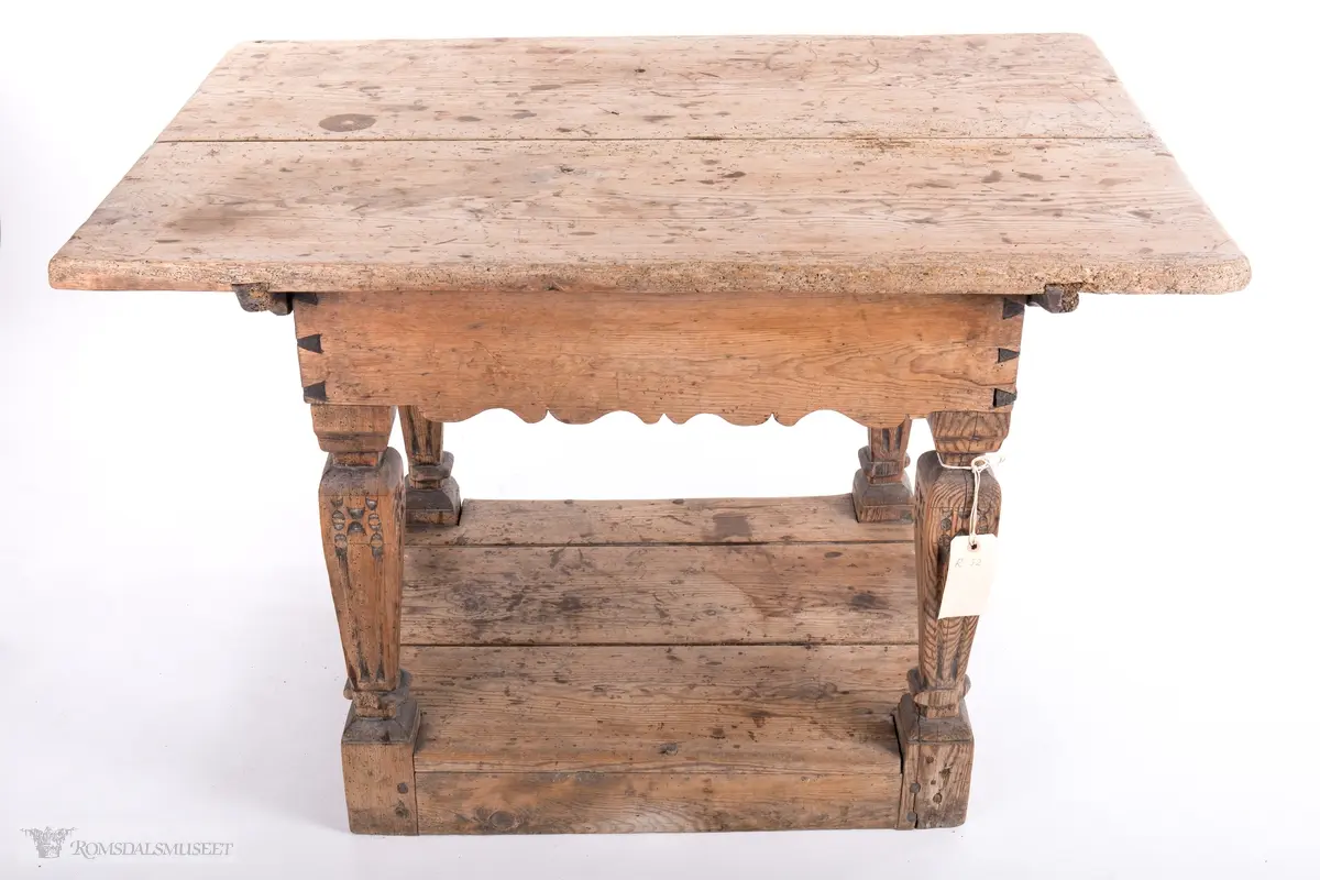 Platen hviler på arkitrav som igjen hviler på koniske pillarer med en form for kannelering med kapitel/terningkapitel og basis. Alt hviler på postamentet med høyde 12 cm.