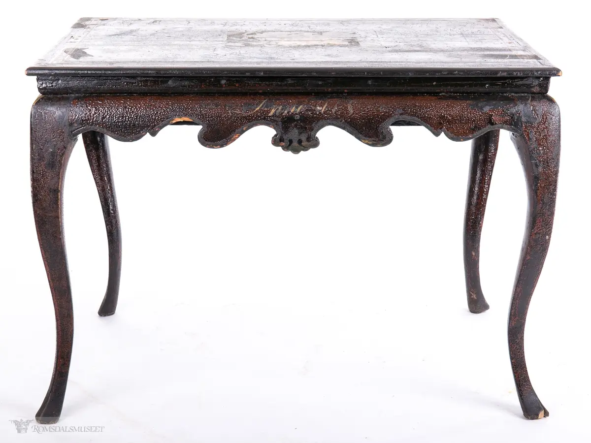 Et stilleben sentralt på bordplaten av en klase med plommer, to fersken, den ene brutt åpen, to nøtter og en fiken.