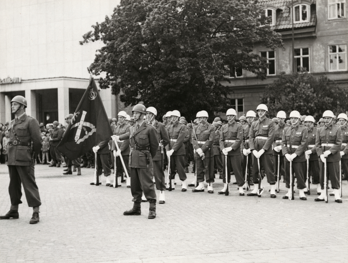 Militärer i uppställning framför konserthuset. Alla bär vita paradhjälmar med tillhörande uniform.