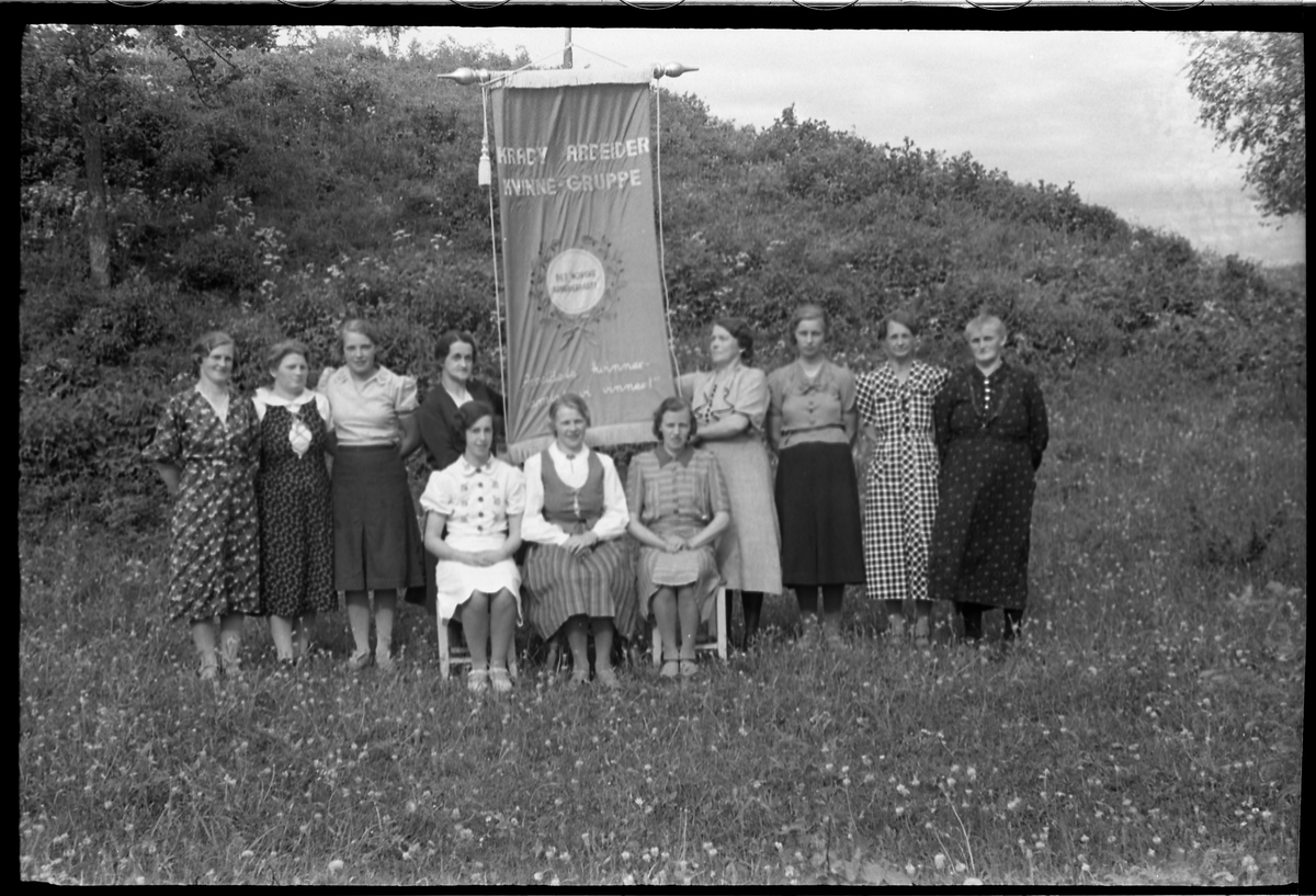 Kraby Arbeiderkvinnegruppe juni 1939. Bildene kan være tatt i forbindelse med at gruppa hadde sin nye fane klar. Serie på 6 bilder. Personene (bilde nr. 1):
Sittende foran fra venstre: Mally Tallerud, Ågot Lier, Nelly Moen. 
Bak fra venstre: Telma Moen, Ellen Lieshagen, Palma Gihleengen, Asta Hansen, Jeanette Tallerud, Mally Solberg, Marie Johansen, Anna Lieshagen.