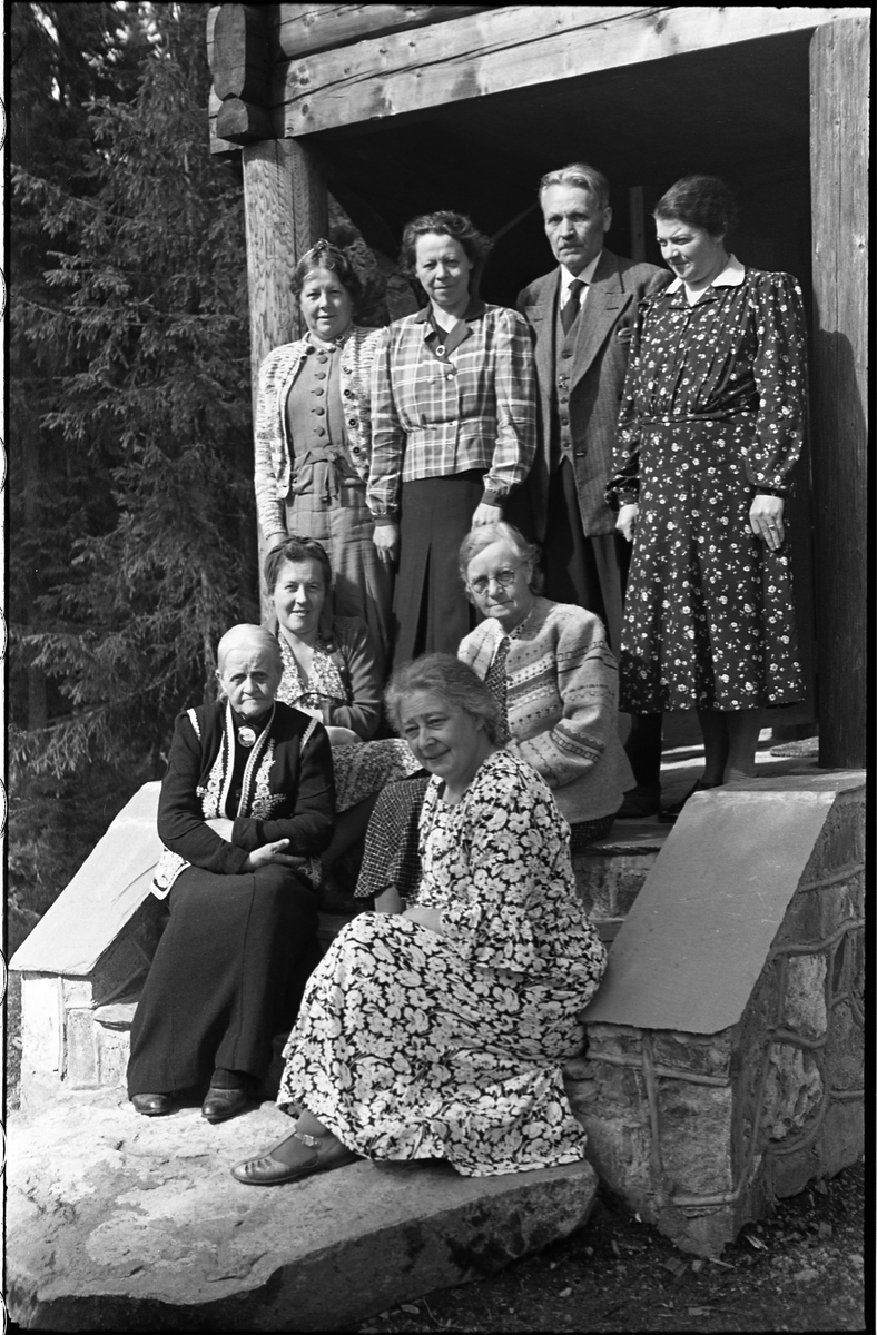 Sogneprest i Hoff, Ingebrigt Hole, og noen kvinner fotografert foran Holes hytte ved Skjeppsjøen på Totenåsen. Fire bilder.
Personene er (plasseringene referer til bilde nr. 1): Fremst til høyre prestens kone, Maria Hole, til venstre for henne Otilie Nøkleby. Bak Othilie sitter hennes datter Olaug (Rust). Kvinnene som står bakerst er Othilie Nøklebys døtre: Lengst til venstre Margit, dernest Borghild, og lengst til høyre Nora. Mellom dem står Ingebrigt Hole. Kvinnen som sitter til høyre i midten er ikke identifisert.