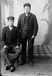 Portrett tatt i atelier av to unge menn. Den ene sittende de