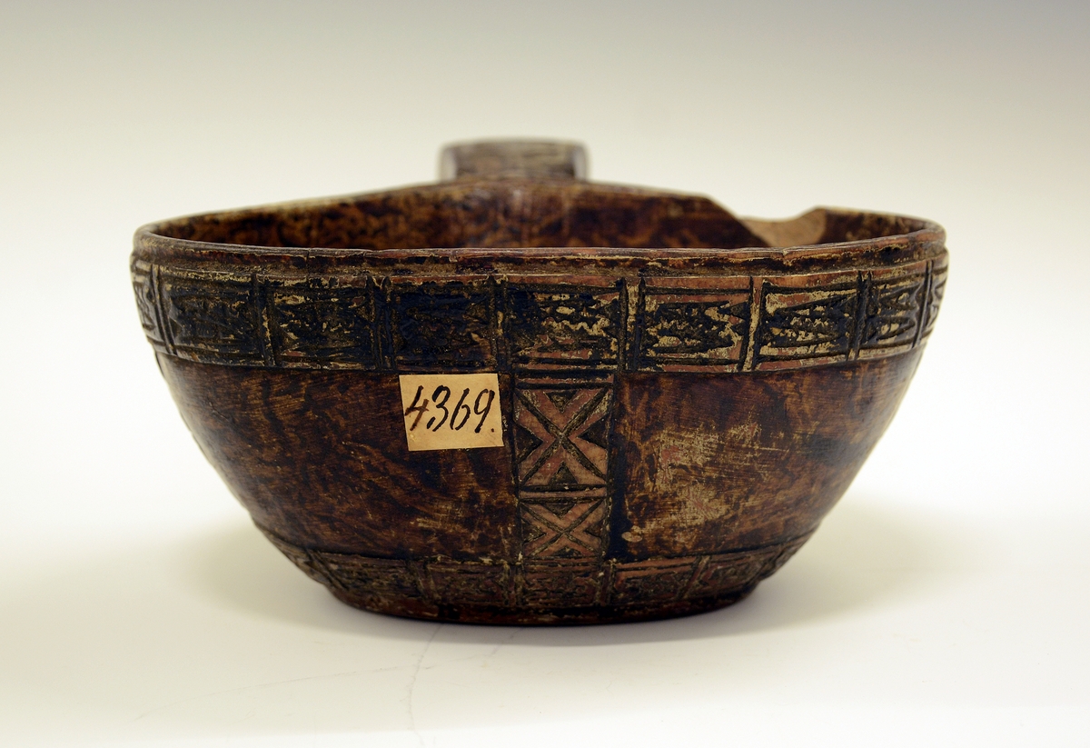 Øløse i tre. Fra protokollen: Øse fra 1806. Under bunden skaaret JTS 1806. Bladorn. paa skaftet. Utenpaa baand av kerbsnitruter, indelt i 4 kanter. Rundt kanten oppe, nede og 5 paa tvers og ett dobbelt ved skaftet.