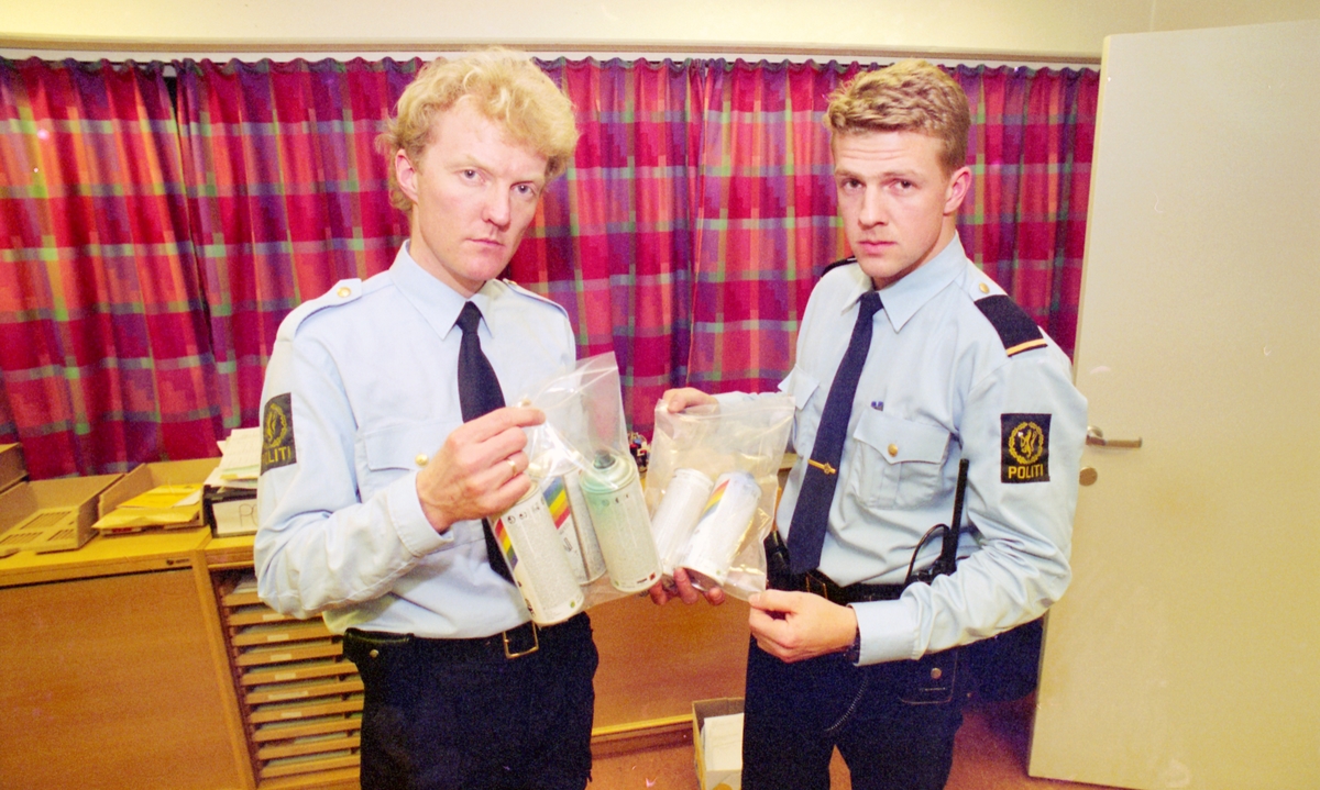 Fra venstre: To politibetjenter med spraybokser i poser.