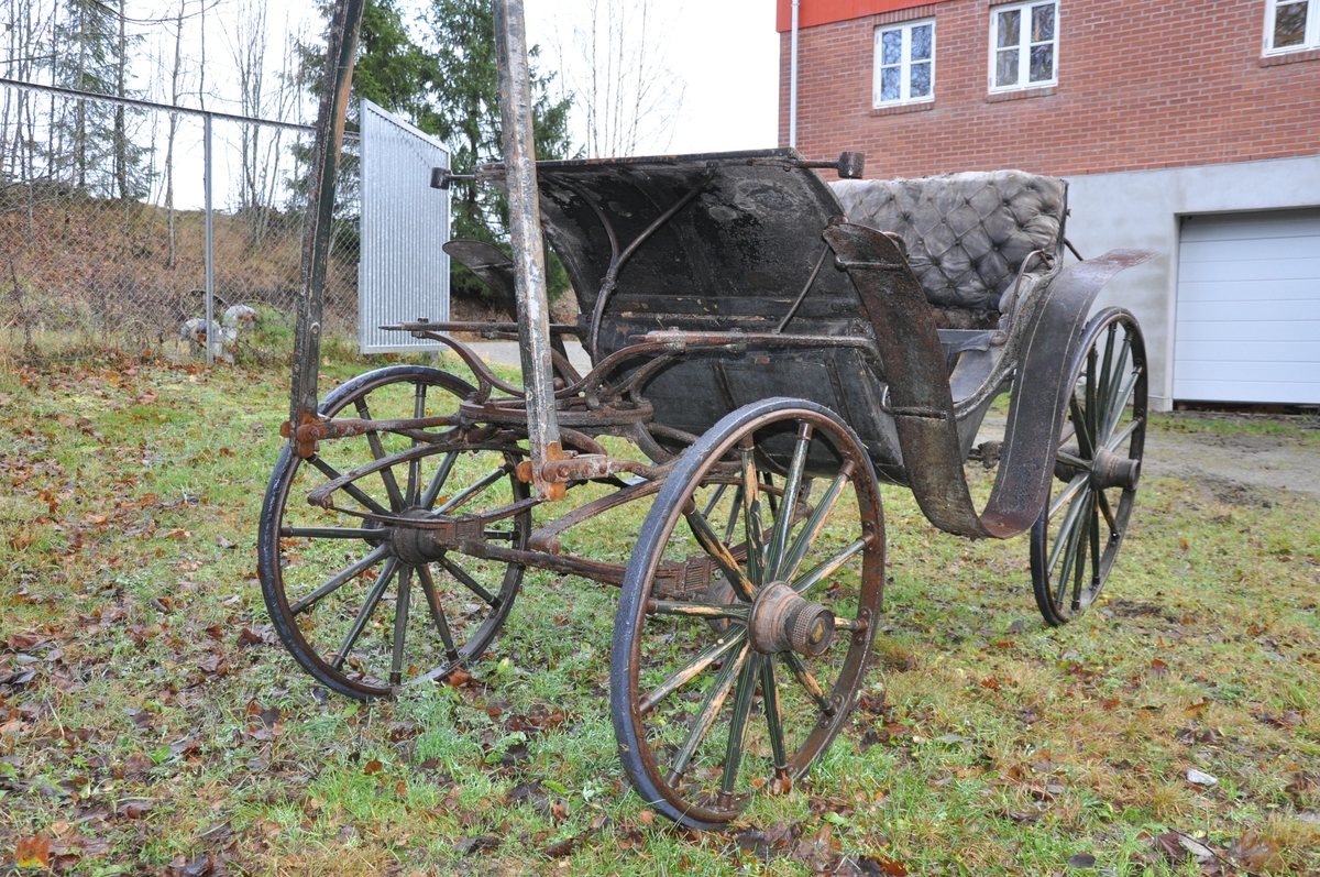 4-hjuls vogn for trekk med én hest. Trilletype. Spesielt stor fløy (skvettskjerm) . Lakeisete bakerst, stort hovedsete, lite motsete.