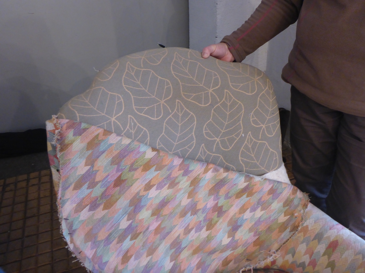 Stolen har en ramme av tre med dreide frambein som er beiset og oljet.