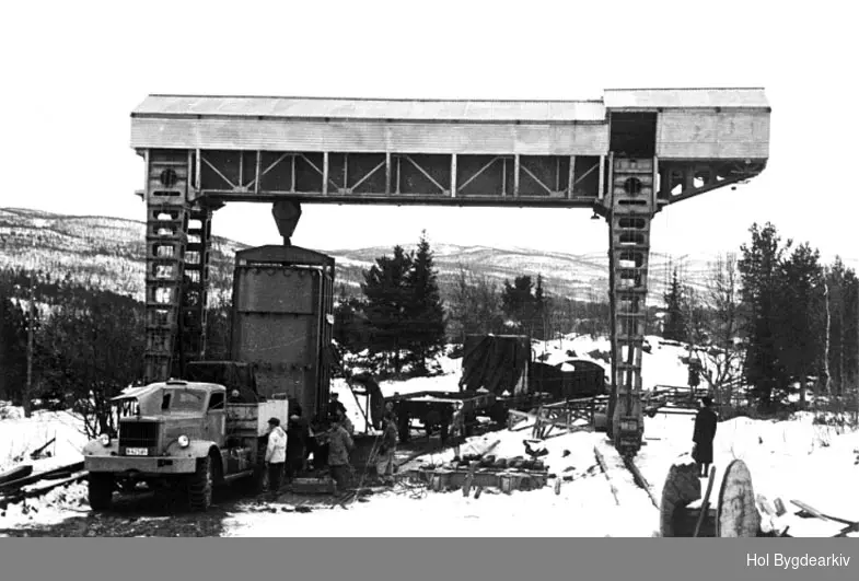 Holsanlegget, kraftutbygging, omlasting, jernbane, kran, lastebil, trekkvogn, arbeidsfolk; Lastebilen er en Diamond T 981 M20 A-42585 ble kjøpt i Frankrike av Oslo lysverk etter krigen