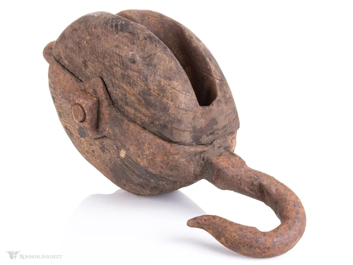 Treblokk med en enkelt skive eller trinse. Et kraftig jernbeslag griper om blokken og er festet med en gjennomgående bolt som er aksling for skiven. Beslaget avsluttets av en jernkrok på den ene siden og en jerning med en påfestet kause i den andre.