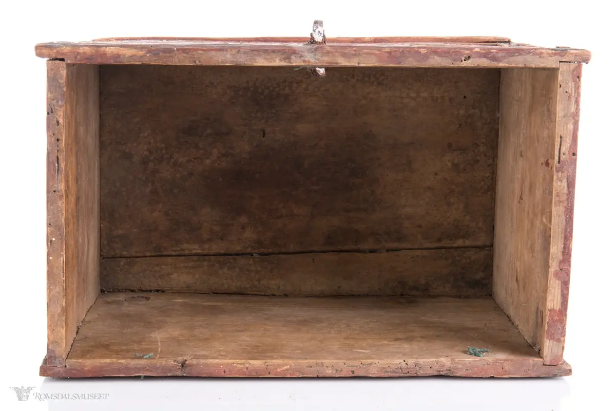 To sammenkomponerte seksbladsrosetter på hver langside. På kortsidene er det skåret ut fire klokkeformede strukturer fylt med spetter og border som til sammen ligner på et noe asymmetrisk solkors/kors.