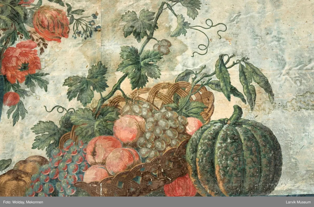 |Tapeten er påmalt tapetborder og brystning. Fra Hovland gård i Larvik.
Den øverste, brede borden: Gerlander/draperi med blomsterranker.
Den nederste, smalere borden: Tekstilbord med blomster. Øver døren til høyre: Stillebenmotiv med blomster og frukt.